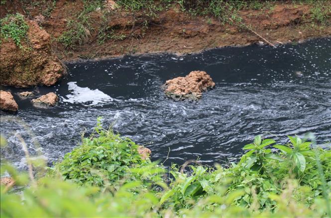 Nước Suối Tân chuyển thành màu đen như mực, đặc quánh, bốc mùi hôi nồng nặc kéo dài hàng chục cây số. Ảnh: Đậu Tất Thành – TTXVN
