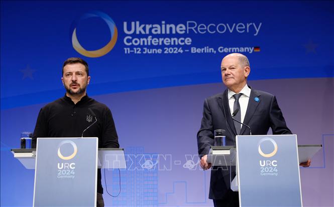 Ngày 11/6/2024, phát biểu tại Hội nghị Tái thiết Ukraine ở Berlin, Thủ tướng Đức Olaf Scholz đã kêu gọi các công ty tư nhân đầu tư cho các dự án tái thiết Ukraine. Về phần mình, Tổng thống Ukraine Volodymyr Zelensky tin tưởng phái đoàn nước này sẽ rời hội nghị với các thỏa thuận trị giá hàng tỷ euro cho ngành công nghiệp quốc phòng và ngành năng lượng. Ảnh: Tổng thống Ukraine Volodymyr Zelensky (trái) và Thủ tướng Đức Olaf Scholz trong cuộc họp báo tại Hội nghị Tái thiết Ukraine ở Berlin. Ảnh: AFP/TTXVN