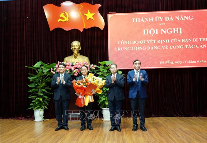 Phó Bí thư Thường trực Thành ủy Đà Nẵng Nguyễn Đình Vĩnh (thứ hai, trái) nhận hoa chúc mừng của lãnh đạo Thành ủy, HĐND, UBND thành phố Đà Nẵng. Ảnh: Quốc Dũng - TTXVN
