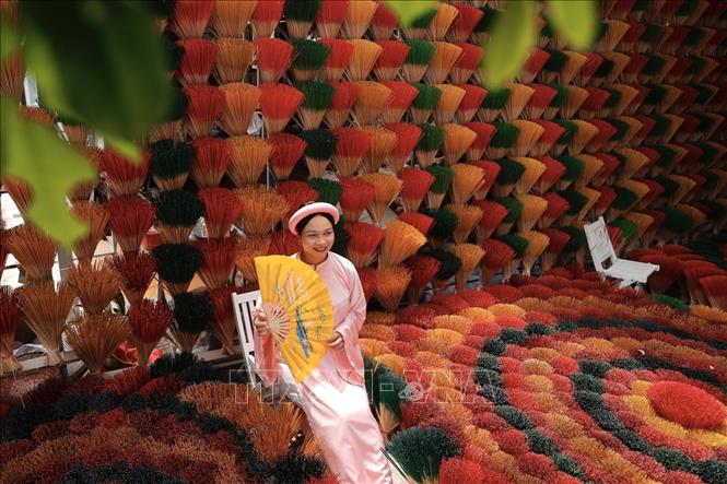 A tourist takes check-in photos at Thuy Xuan incense village. VNA Photo