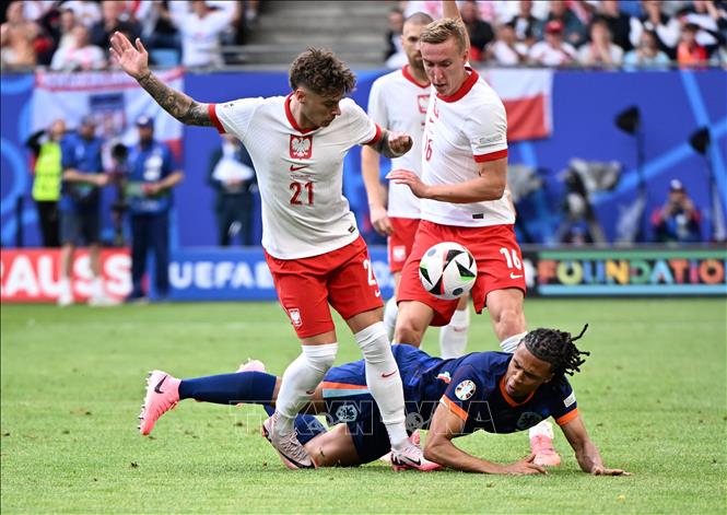 Nathan Ake (áo xanh) của Hà Lan nỗ lực tranh bóng với các cầu thủ Ba Lan. Ảnh: THX/TTXVN