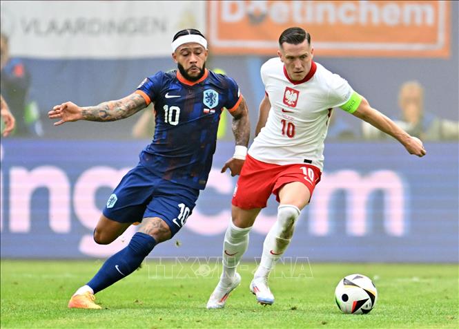 Memphis Depay (trái) của Hà Lan tranh bóng với Piotr Zielinski của Ba Lan. Ảnh: THX/TTXVN