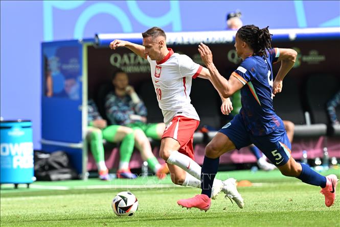 Przemyslaw Frankowski (trái) của Ba Lan tranh bóng với Nathan Ake của Hà Lan. Ảnh: THX/TTXVN