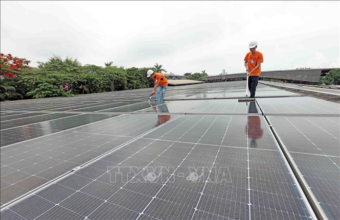 Vệ sinh bề mặt tấm pin mặt trời áp mái tại nhà máy Maxport 8, huyện Vũ Thư, Thái Bình. Ảnh: Trần Việt - TTXVN