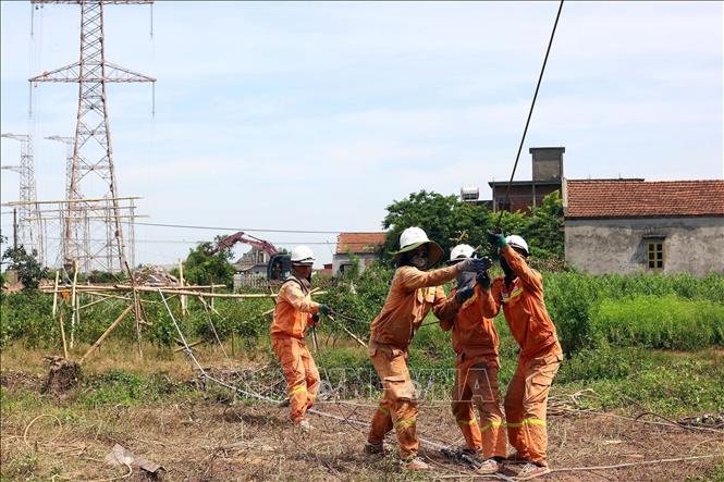 Căng mình kéo dây giữa thời tiết nóng bức trên tuyến đường dây Nhà máy nhiệt điện Nam Định 1 - Phố Nối tại huyện Nghĩa Hưng, tỉnh Nam Định. Ảnh: Huy Hùng - TTXVN