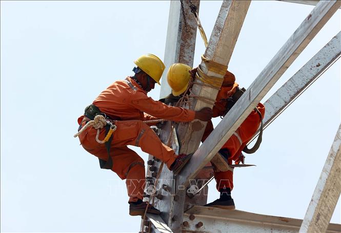 Thi công lắp dựng cột 32 tuyến đường dây Nhà máy nhiệt điện Nam Định 1 - Phố Nối giữa trưa nắng tại huyện Trực Ninh, tỉnh Nam Định. Ảnh: Huy Hùng - TTXVN