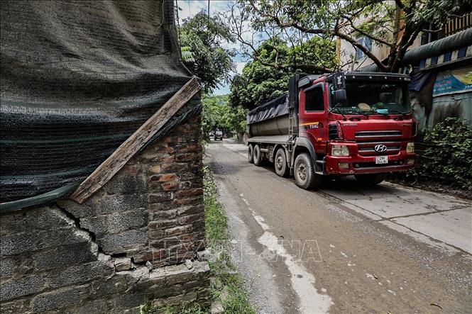 Một góc nhà người dân tại ngõ 41 đường Tô Vĩnh Diện hướng đi về xã Tân Vinh phủ kín lưới để che bụi và góc tường bị ảnh hưởng từ rung chấn của cường độ vận chuyển đất đá của các xe tải cỡ lớn. Ảnh: Trọng Đạt - TTXVN 