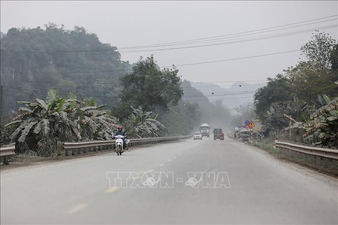 Bụi, khói như màn sương, cây lá hai bên đường bạc trắng do nổ mìn khai thác, do những chuyến xe vận chuyển đất đá ra vào tại các mỏ trên đường Hồ Chí Minh đoạn qua các mỏ đá khu vực xã Cao Dương (Lương Sơn, Hòa Bình). Ảnh: Trọng Đạt - TTXVN