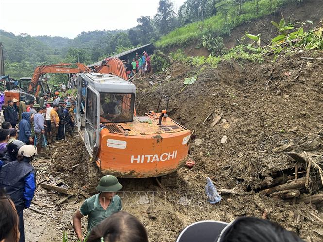 Lực lượng chức năng tìm kiếm cứu nạn hộ gia đình bị sạt lở vùi lấp. Ảnh: TTXVN phát