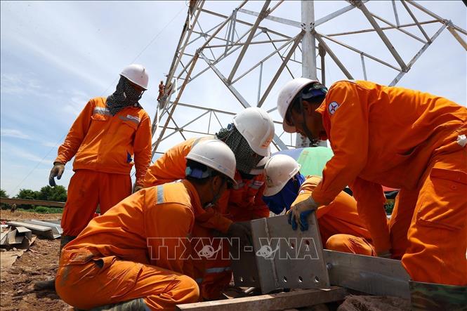 Workers work hard in harsh conditions of summer heat. VNA Photo: Huy Hùng 