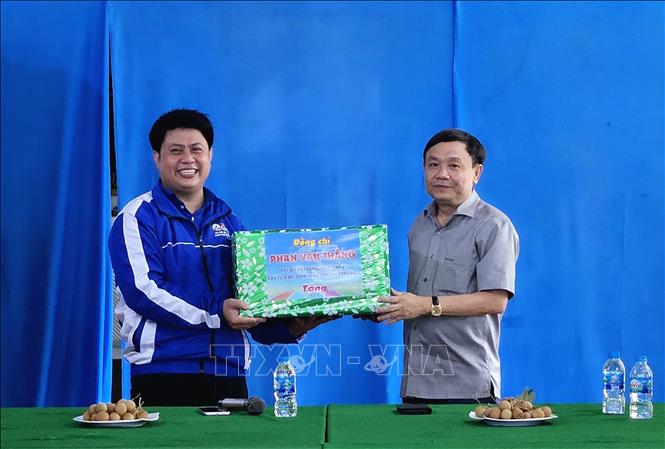 Phó Bí thư Thường trực Tỉnh ủy Đồng Tháp Phan Văn Thắng (bên phải) trao quà cho đại diện sinh viên tình nguyện Trường Đại học Công nghiệp Thành phố Hồ Chí Minh. Ảnh: TTXVN phát