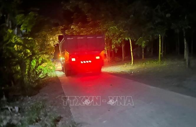Xe ben chở đất khai thác trái phép trong đêm. Ảnh: TTXVN phát
