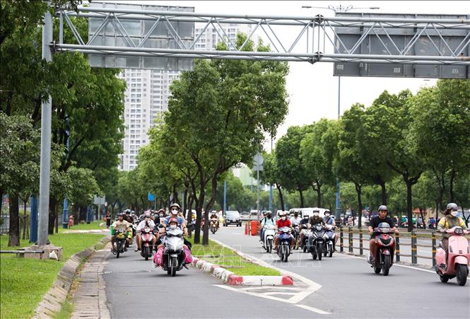 Cây xanh và dải phân cách bêtông sẽ được tháo dỡ để mở rộng làn đường dành cho xe máy trên đại lộ Võ Văn Kiệt phía kênh Tàu Hủ. Ảnh: Hồng Đạt - TTXVN
