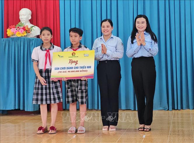 Bí thư Trung ương Đoàn, Chủ tịch Hội đồng Đội Trung ương Nguyễn Phạm Duy Trang (bên phải) trao bảng tượng trưng sân chơi cho thanh thiếu nhi trị giá 90 triệu đồng cho thiếu nhi xã Châu Bình, huyện Giồng Trôm, tỉnh Bến Tre. Ảnh: Chương Đài - TTXVN