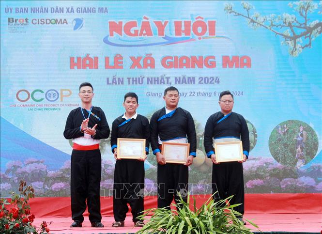 Ban tổ chức trao Giấy Chứng nhận tôn vinh cho 3 hộ gia đình có thành tích tiêu biểu trong công tác trồng, chăm sóc và phát triển cây lê trên địa bàn xã Giang Ma. Ảnh: Quý Trung – TTXVN