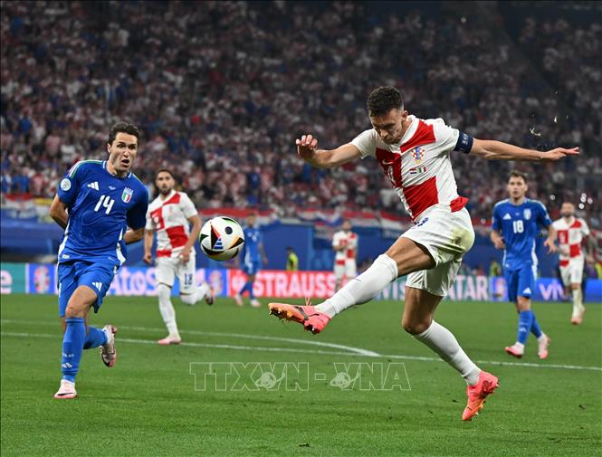 Tiền vệ Ivan Perisic (phải) của Croatia dứt điểm về phía khung thành tuyển Italy. Ảnh: THX/TTXVN