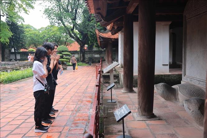 Thí sinh cầu may mắn tại khu vực nhà bia tiến sĩ Khu di tích quốc gia đặc biệt Văn Miếu – Quốc Tử Giám. Ảnh: Hoàng Hiếu - TTXVN
