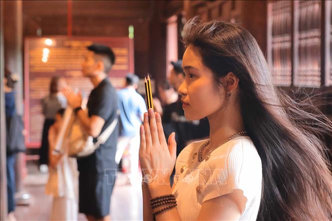 Thí sinh mang bút đến cầu mong làm bài tốt, đạt được kết quả cao trong kỳ thi sắp tới. Ảnh: Hoàng Hiếu - TTXVN