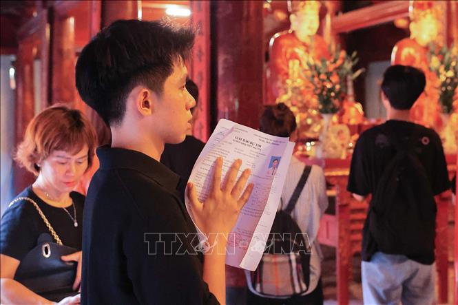Một thí sinh mang cả giấy báo dự thi đến cầu thi tốt. Ảnh: Hoàng Hiếu - TTXVN