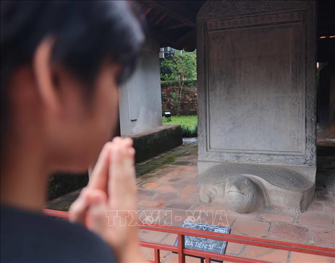 Thí sinh cầu may mắn tại khu vực nhà bia tiến sĩ Khu di tích quốc gia đặc biệt Văn Miếu – Quốc Tử Giám. Ảnh: Hoàng Hiếu - TTXVN