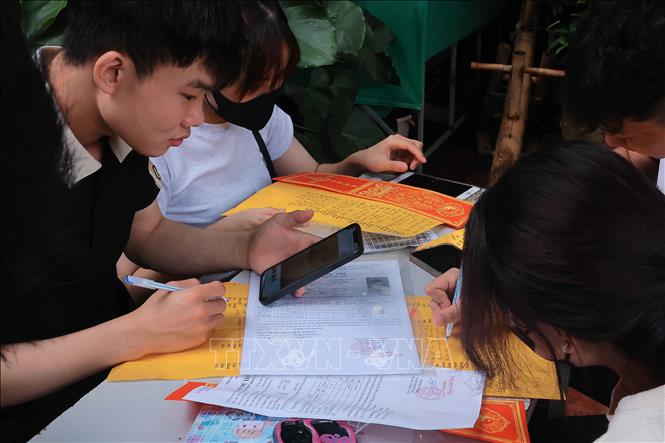 Nhiều thí sinh viết sớ, cầu mong thi tốt. Ảnh: Hoàng Hiếu - TTXVN 