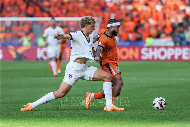 Pha tranh bóng quyết liệt giữa Memphis Depay (phải) tuyển Hà Lan và cầu thủ Áo. Ảnh: THX/TTXVN