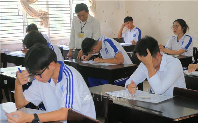Thí sinh xem tại điểm thi trường THPT Long Xuyên, thành phố Long Xuyên, tỉnh An Giang kiểm tra lại thông tin cá nhân trước kỳ thi. Ảnh: Công Mạo-TTXVN