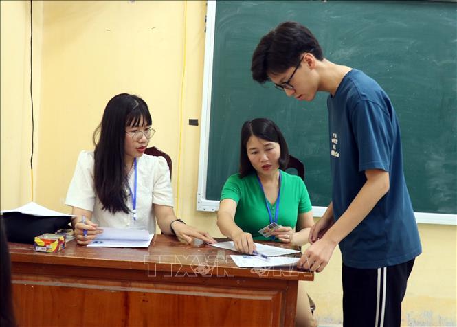 Cán bộ coi thi tại điểm Trường THPT Chuyên Hưng Yên hướng dẫn thí sinh làm thủ tục dự thi. Ảnh: Mai Ngoan-TTXVN