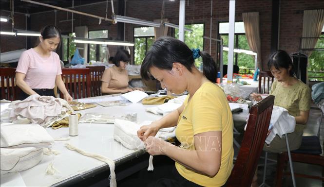 Các nghệ nhân, thợ thủ công làng nghề thêu ren Văn Lâm hoàn thiện sản phẩm. Ảnh: Thùy Dung - TTXVN