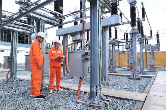 Nhân viên điện lực kiểm tra các tủ bảng điều khiển thiết bị. Ảnh: Tuấn Anh - TTXVN