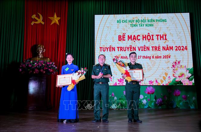 Đại tá Nguyễn Văn Dũng, Phó Chính ủy Bộ Chỉ huy Bộ đội Biên phòng tỉnh Tây Ninh (giữa) trao giải Tuyên truyền viên Xuất sắc cho 2 cá nhân. Ảnh: Giang Phương – TTXVN
