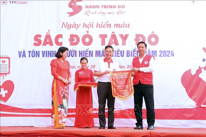 Ban Chỉ đạo vận động hiến máu tình nguyện thành phố Cần Thơ tiếp nhận Cờ lưu niệm và Biểu trưng từ Ban tổ chức Hành trình đỏ Trung ương. Ảnh: Trung Kiên - TTXVN