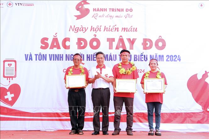 Ban tổ chức tôn vinh, khen thưởng hộ gia đình và cá nhân có thành tích xuất sắc trong công tác hiến máu tình nguyện. Ảnh: Trung Kiên - TTXVN