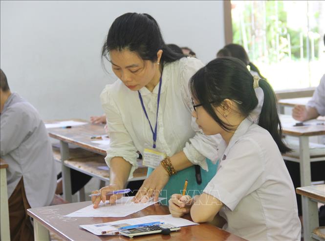 Giám thị hỗ trợ thí sinh các nội dung điền trên giấy nháp và giấy làm bài thi. Ảnh: Phan Sáu - TTXVN