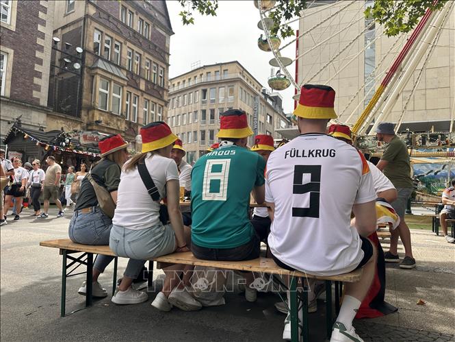 Các cổ động viên Đức tập trung ăn, uống trước khi ra sân xem trận Đức - Đan Mạch. Họ luôn tiêu thụ một lượng bia và đồ ăn rất lớn trước, trong và sau các trận đấu. Ảnh: Anh Ngọc - PV TTXVN từ Dortmund (Đức)