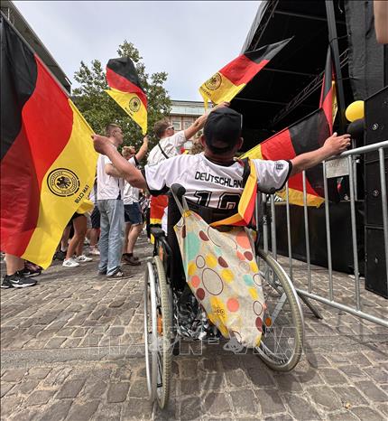 Một cổ động viên khuyết tật tham gia cuộc vui của người hâm mộ đội tuyển Đức ở trung tâm Dortmund do Hiệp hội hâm mộ đội tuyển Đức tổ chức trước trận gặp Đan Mạch. Ảnh: Anh Ngọc - PV TTXVN từ Dortmund (Đức)

