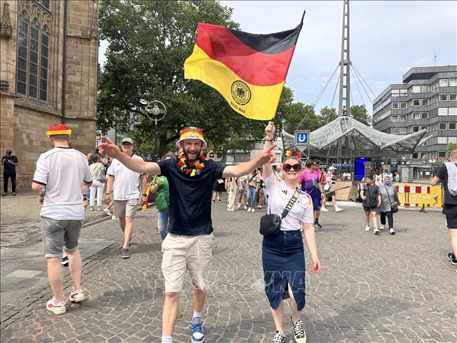 Hai cổ động viên cùng nhau giương cao lá quốc kỳ Đức. Ảnh: Anh Ngọc - PV TTXVN từ Dortmund (Đức)