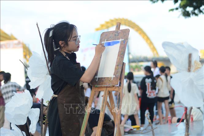 Giáo viên hướng dẫn cho các bạn nhỏ tham gia trải nghiệm vẽ tranh tại chương trình. Ảnh: Văn Dũng-TTXVN