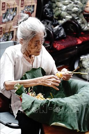 Công đoạn lấy gạo sen được coi là khó nhất trong các bước làm trà sen đòi hỏi người nghệ nhân phải nhanh tay, khéo léo để hạt gạo không nát, bay mất hương thơm, giảm chất lượng của sản phẩm. Ảnh: Khánh Hoà – TTXVN 