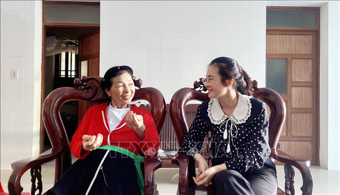 Cán bộ huyện Vân Đồn trò chuyện cùng người dân xã Bình Dân về bảo tồn làn điệu sọong cô của người Sán Dìu. Ảnh: Thanh Vân-TTXVN 