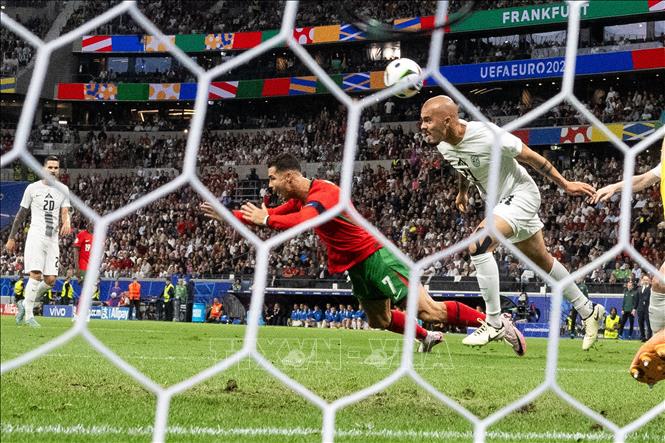 Pha tranh bóng giữa cầu thủ Cristiano Ronaldo (giữa) tuyển Bồ Đào Nha và Vanja Drkusic tuyển Slovenia. Ảnh: THX/TTXVN