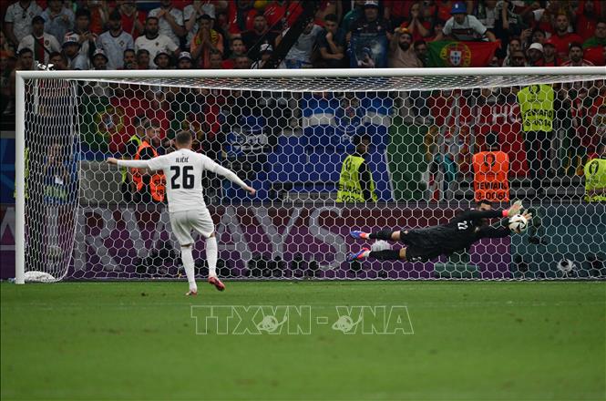 Thủ thành Bồ Đào Nha Diogo da Costa (phải) cản phá thành công cú sút penalty của Josip Ilicic đội tuyển Slovenia. Ảnh: THX/TTXVN