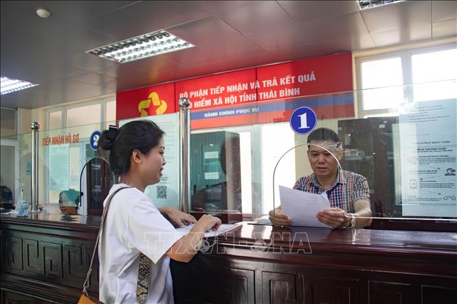 Cán bộ Bảo hiểm tỉnh Thái Bình tiếp người dân đến giải quyết thủ tục liên quan đến bảo hiểm. Ảnh: Vũ Quang – TTXVN