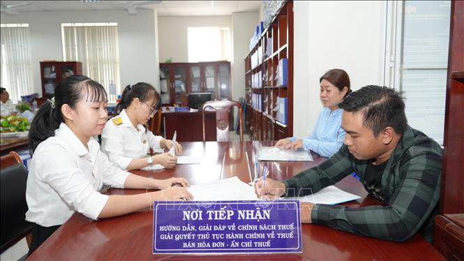 Cán bộ Chi cục Thuế khu vực Hòa Thành - Dương Minh Châu, tỉnh Tây Ninh hướng dẫn, giải đáp về chính sách, thủ tục hành chính về thuế. Ảnh: Minh Phú - TTXVN