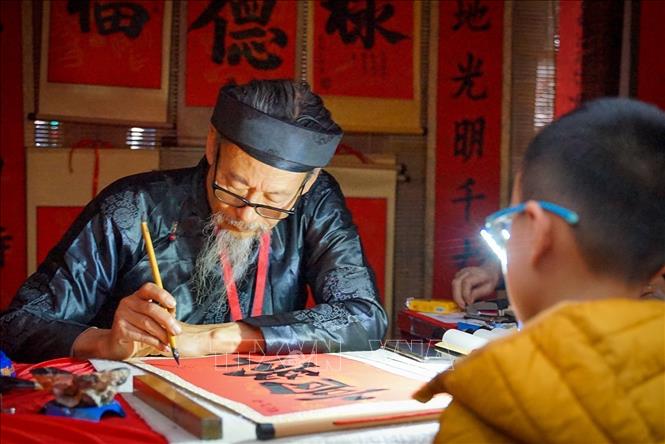 Xin chữ đầu năm mới tại Văn Miếu - Quốc Tử Giám (Hà Nội) cầu mong năm mới đạt được nhiều thành tích tốt trong học, một nét đẹp văn hoá của người Việt Nam nói chung và của người Hà Nội nói riêng. Ảnh: Khánh Hoà - TTXVN