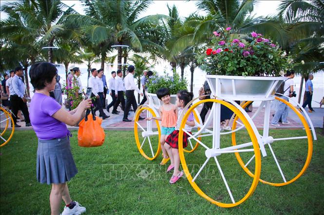 Các em nhỏ thích thú khi được đưa đến đường hoa biển để vui chơi, chụp ảnh. Ảnh: Trần Lê Lâm - TTXVN 