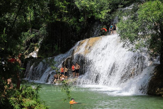 Du khách dưới chân thác Trăng. Ảnh: Trọng Đạt-TTXVN