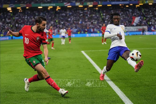 Tiền vệ Bồ Đào Nha Bernardo Silva (trái) tranh bóng với tiền vệ Pháp Eduardo Camavinga. Ảnh: THX/TTXVN