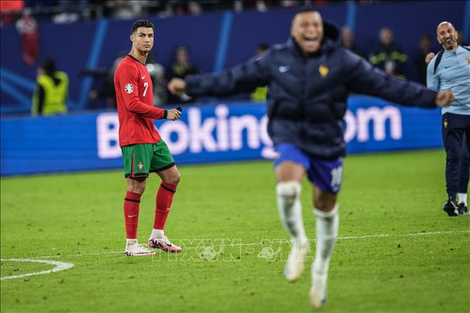Cristiano Ronaldo (trái) buồn bã khi đội nhà thất bại trước tuyển Pháp của Kylian Mbappé (giữa). Ảnh: THX/TTXVN