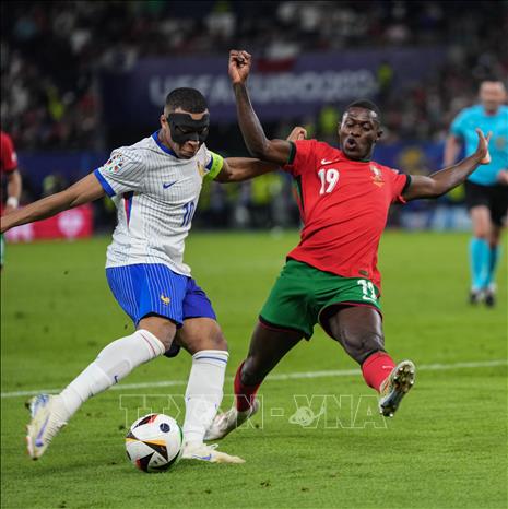 Pha tranh bóng giữa tiền đạo Pháp Kylian Mbappe (trái) với Nuno Mendes của Bồ Đào Nha. Ảnh: THX/TTXVN